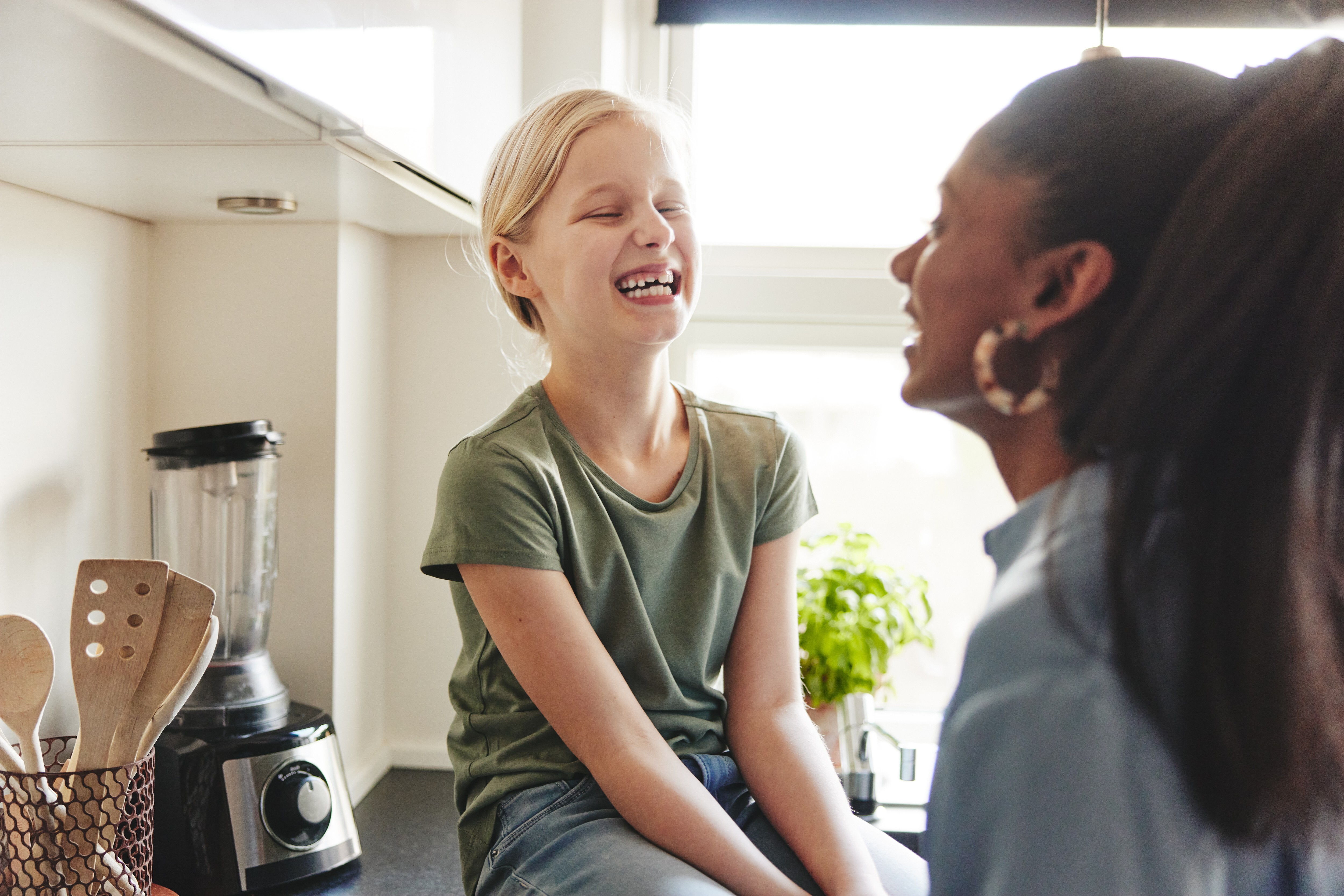 A young girl laughing with a woman beside her
